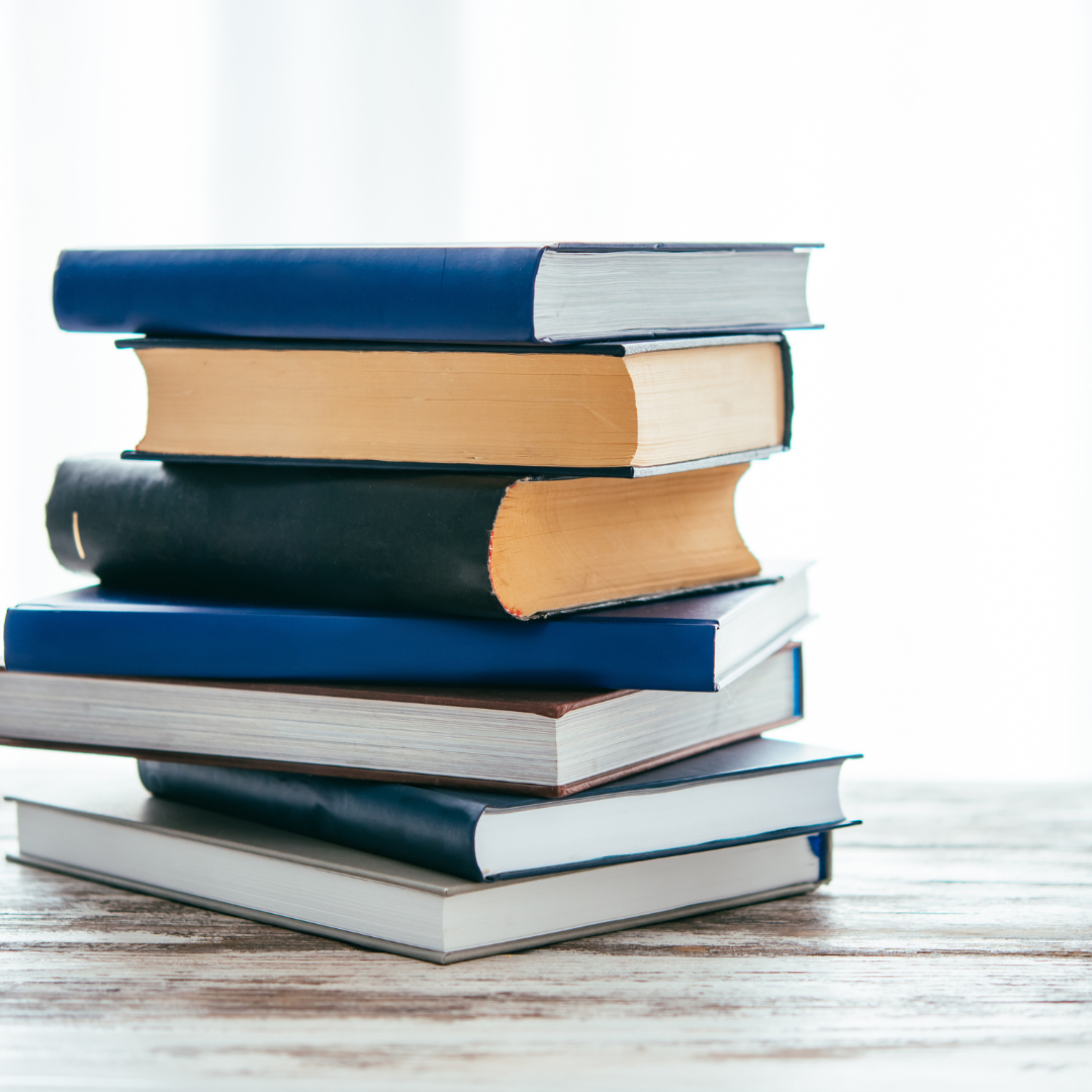 A set of 7 books at stacked unevenly. 