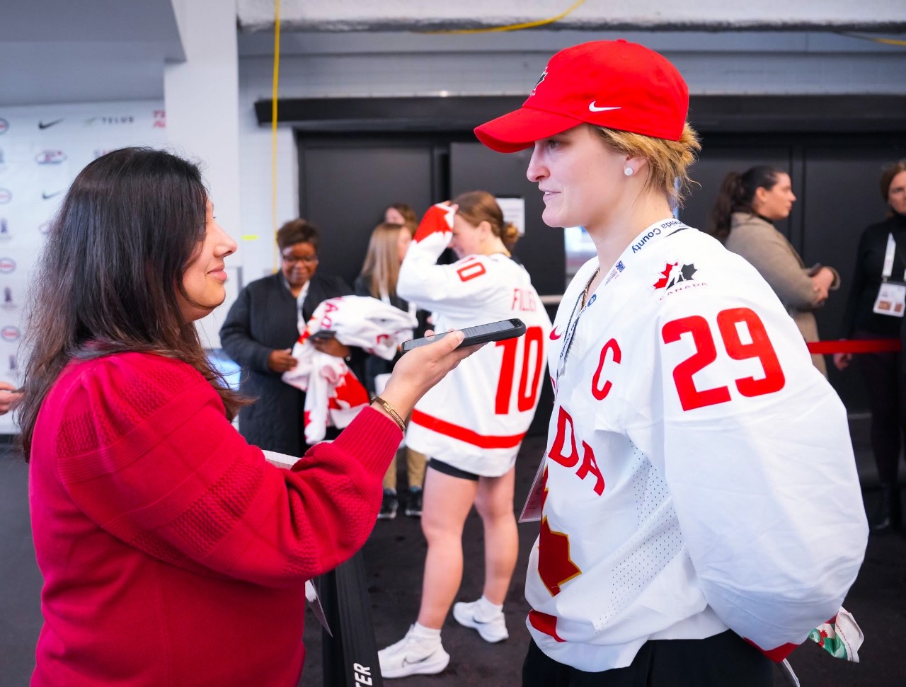 Vohra holds her device for the player's response during a press event.