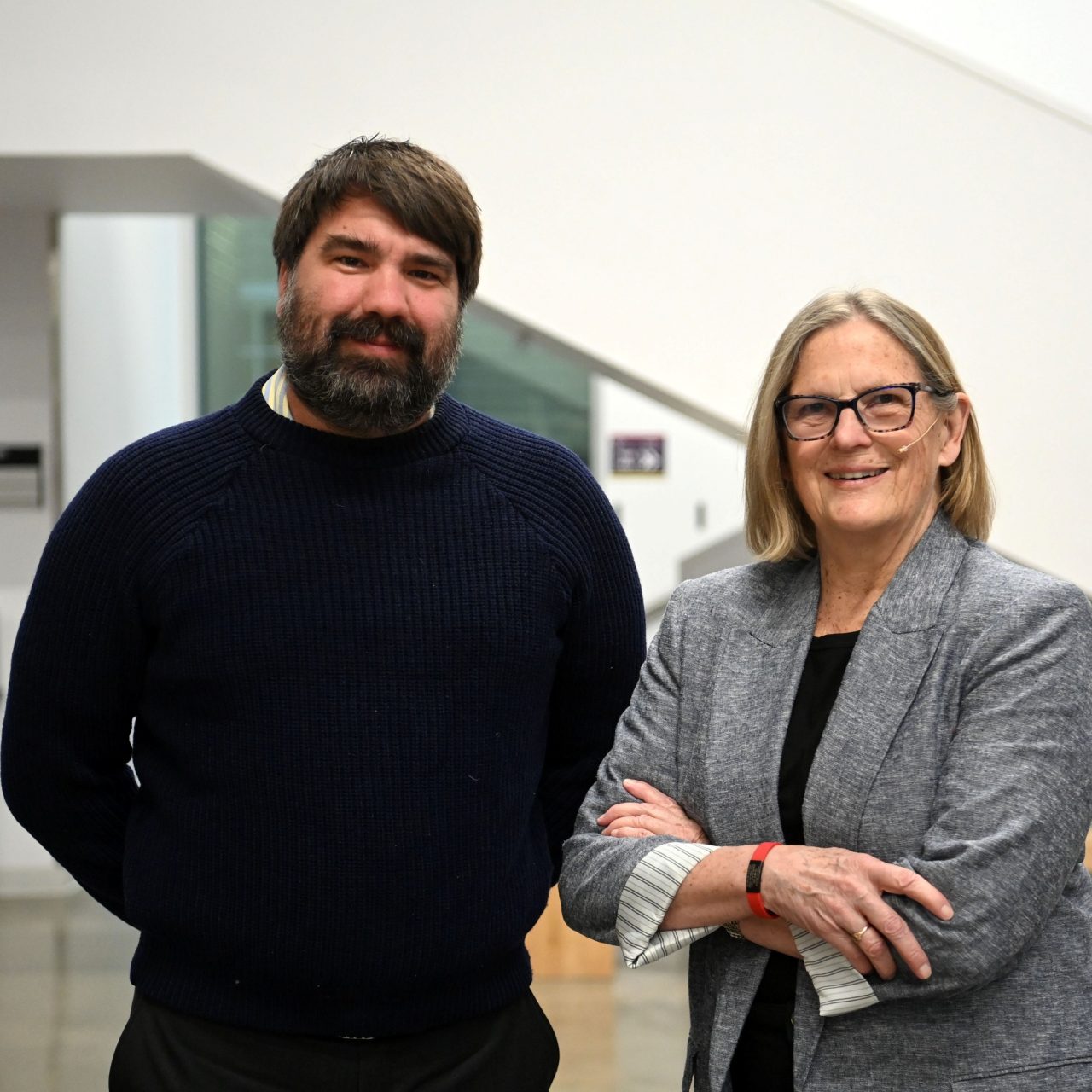 David Barclay stands with his arms behind his back next to Kathryn Sullivan with her arms crossed in front at the event.