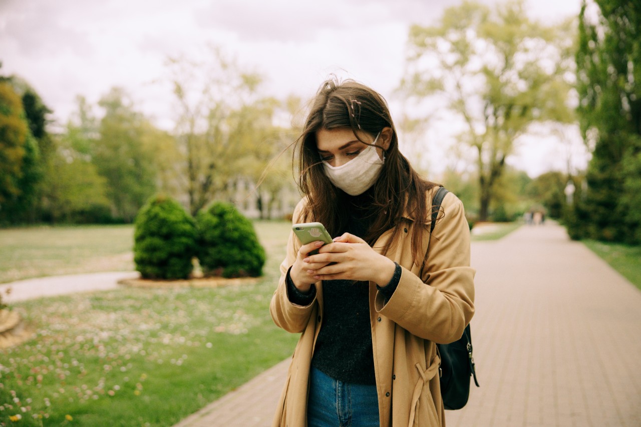 Woman on phone outdoors wearing a face mask