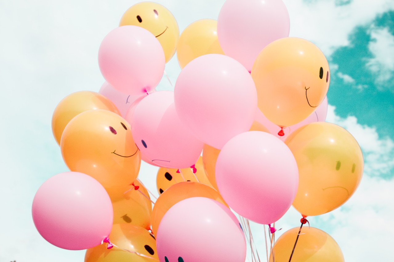 pink and yellow baloons with smiley faces