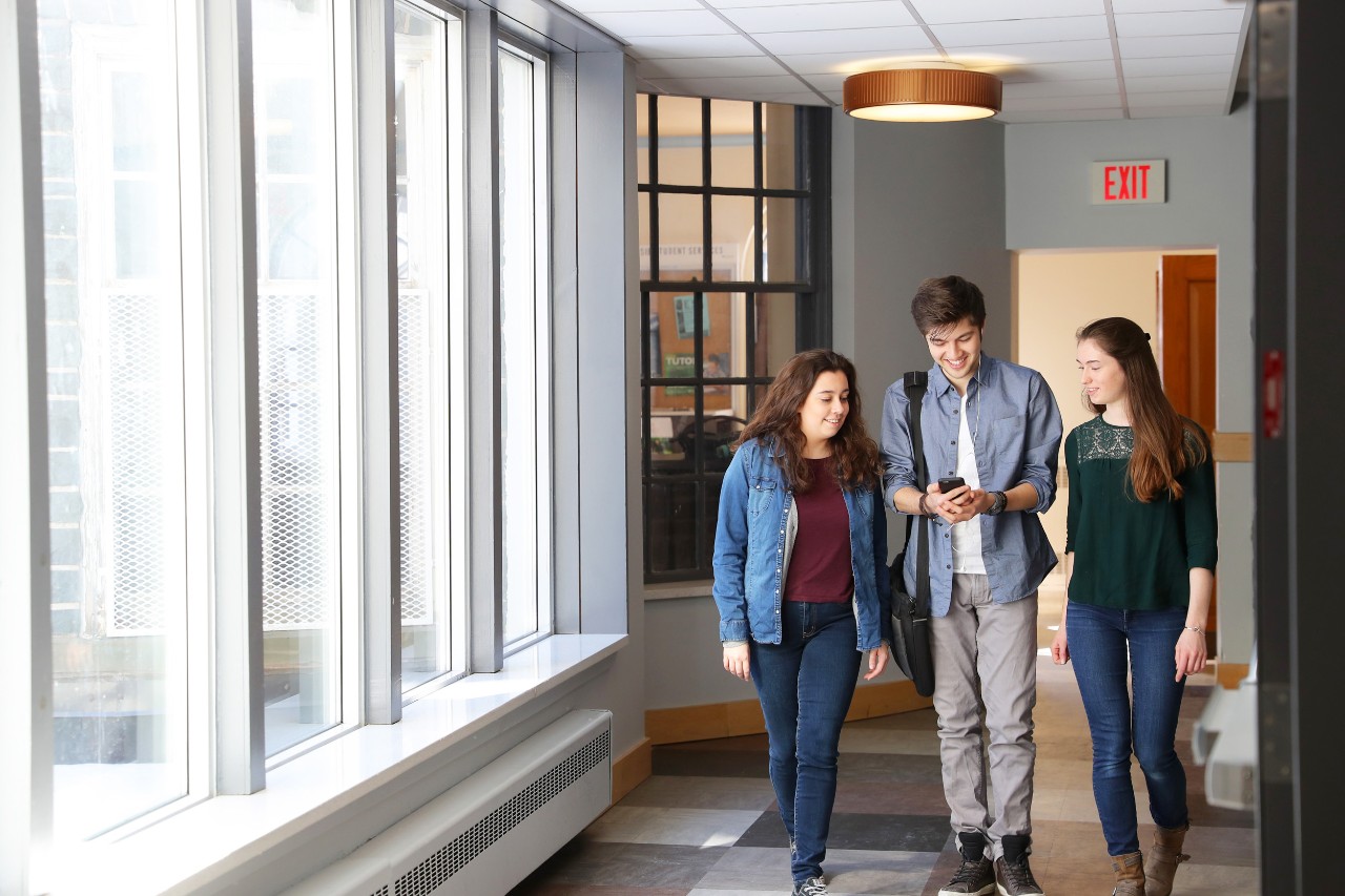 Three residence students walk in a hallway in Howe Hall 