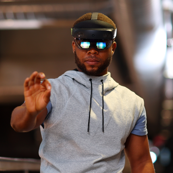 A man wearing a virtual reality headset reaches out to grab something