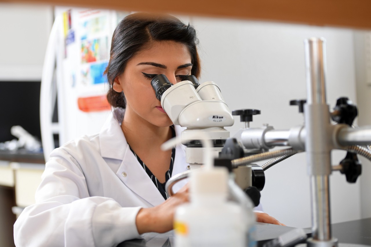 student looking into a microscope