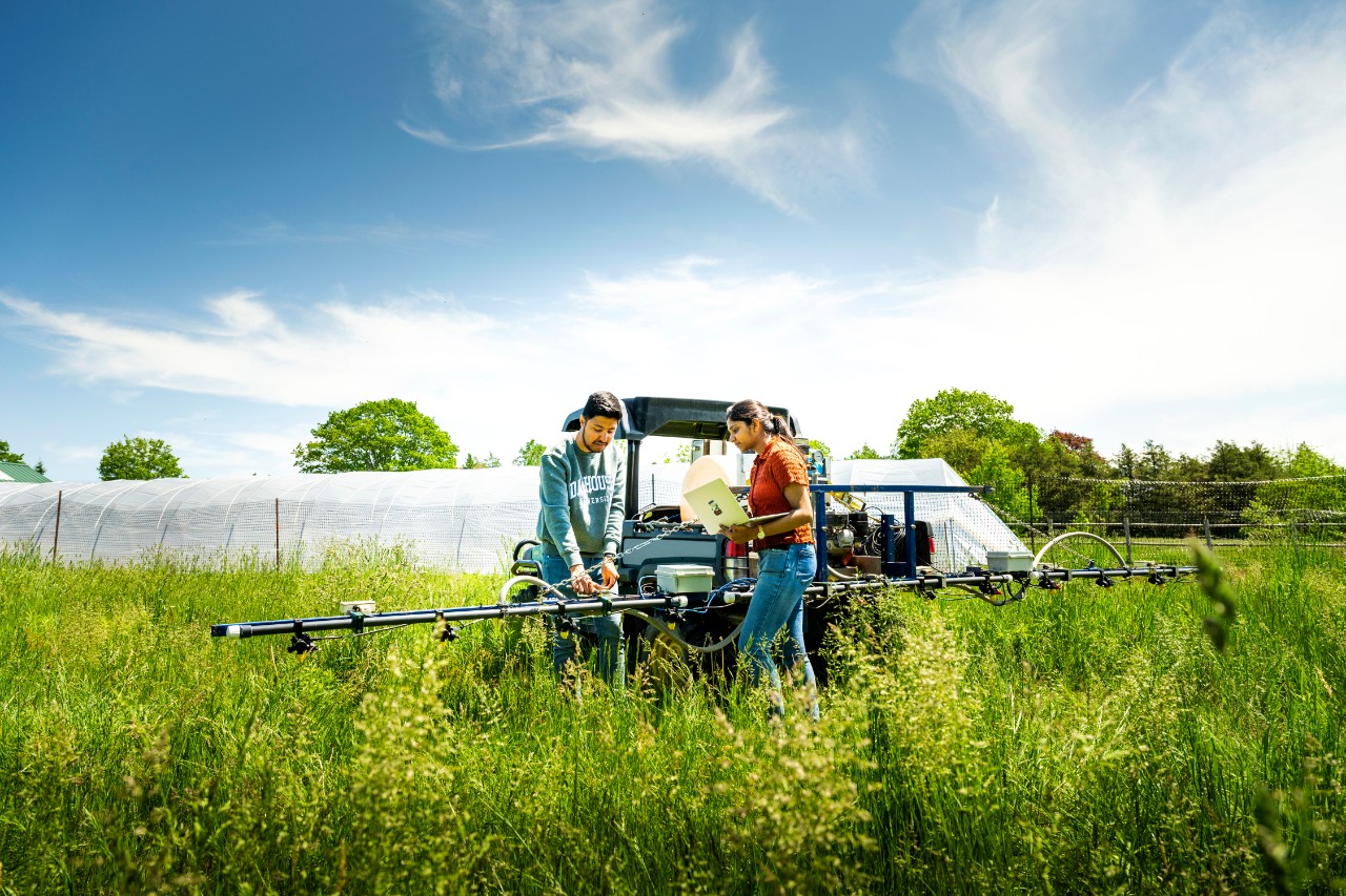 Agriculture students with machinery in a field