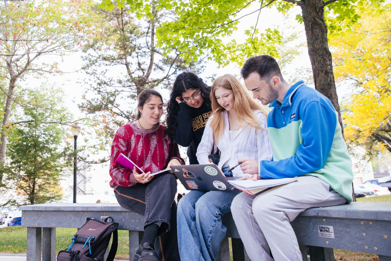students outside campus on a bench
