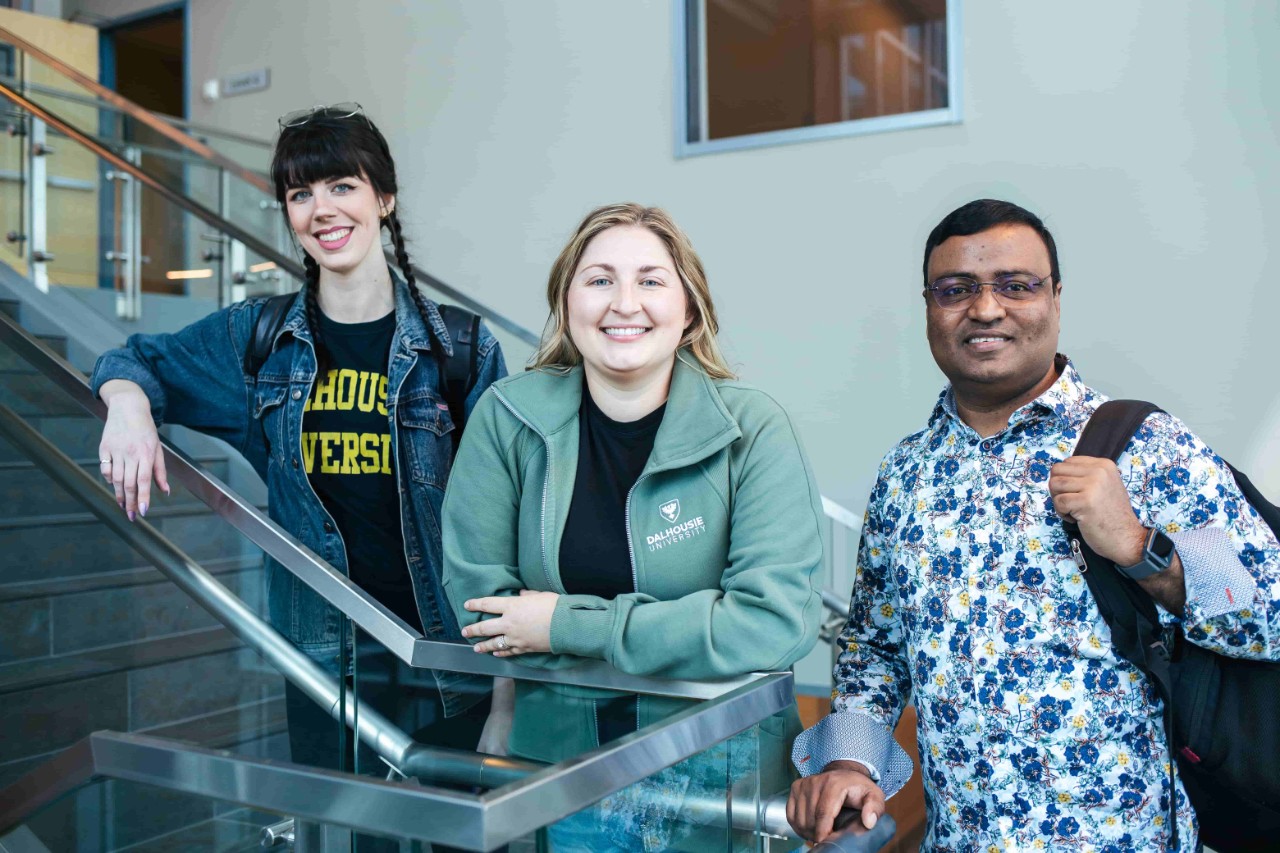 Three graduate students standing on stairs