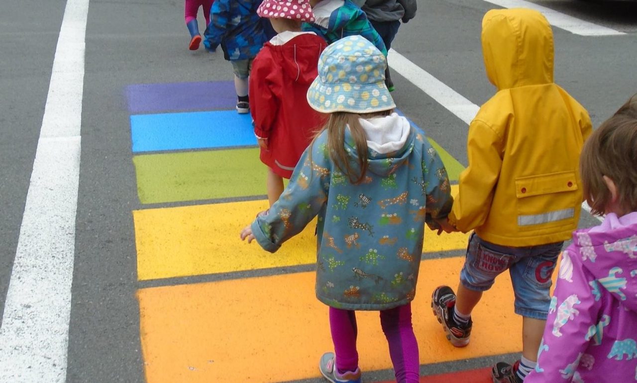 A group of children from Dalhousie's daycare walk across a rainbow painted crosswalk.
