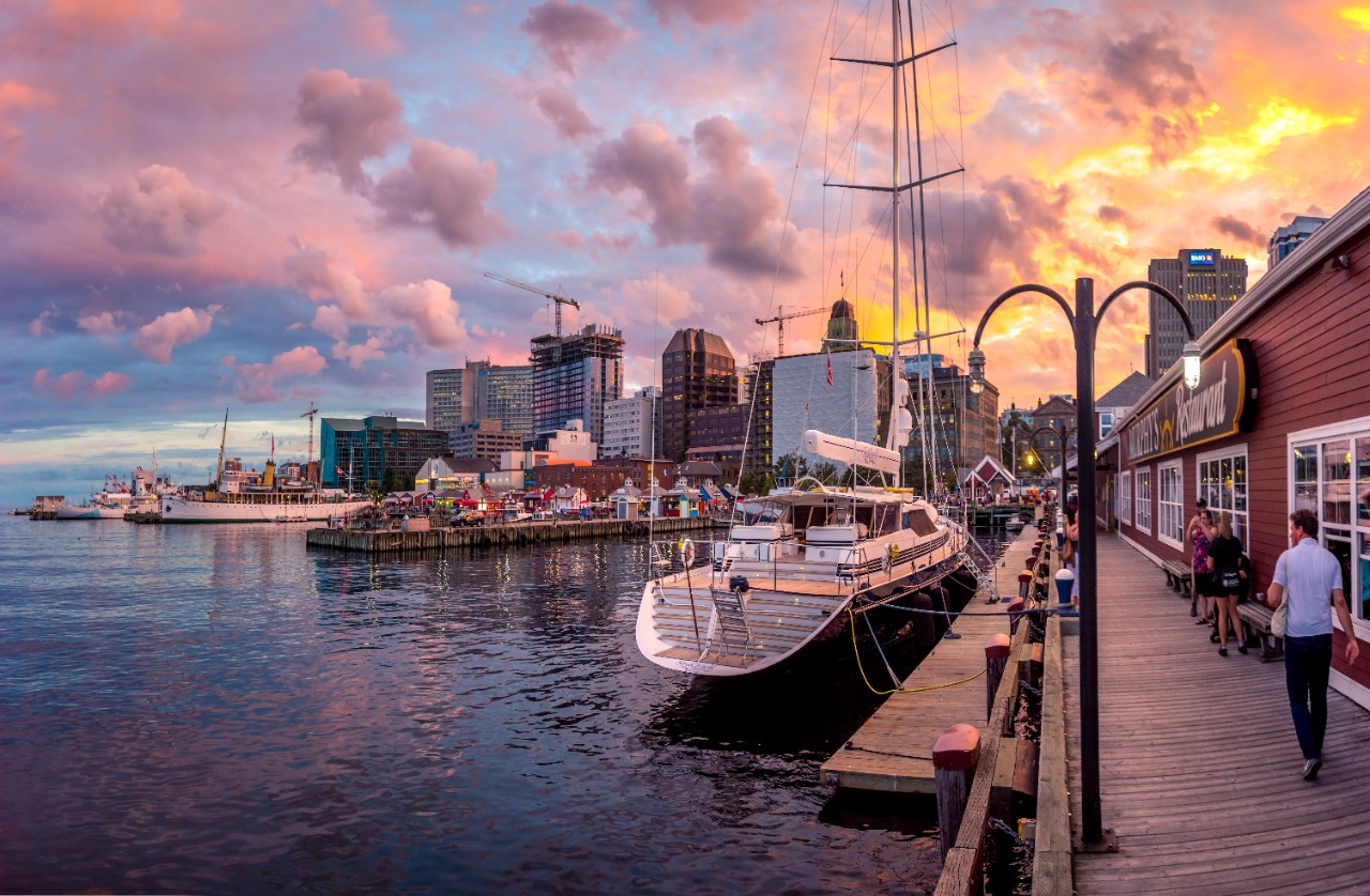 The Halifax waterfront at sunset, with a view of the cloudy sky and the boardwalk.