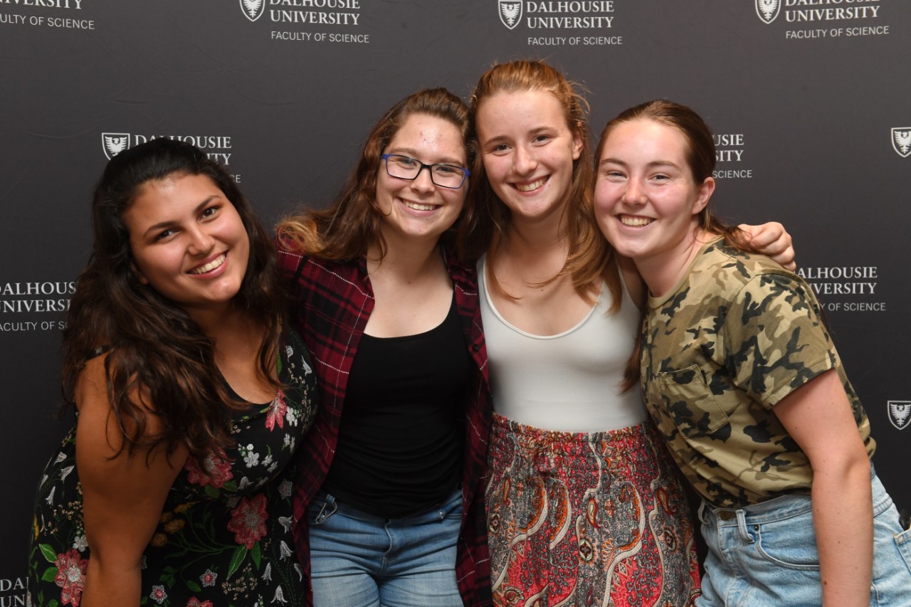 Students pose for a photo in front of a backdrop while they attend the Dalhousie Science welcome party