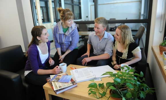Four students chat in an office