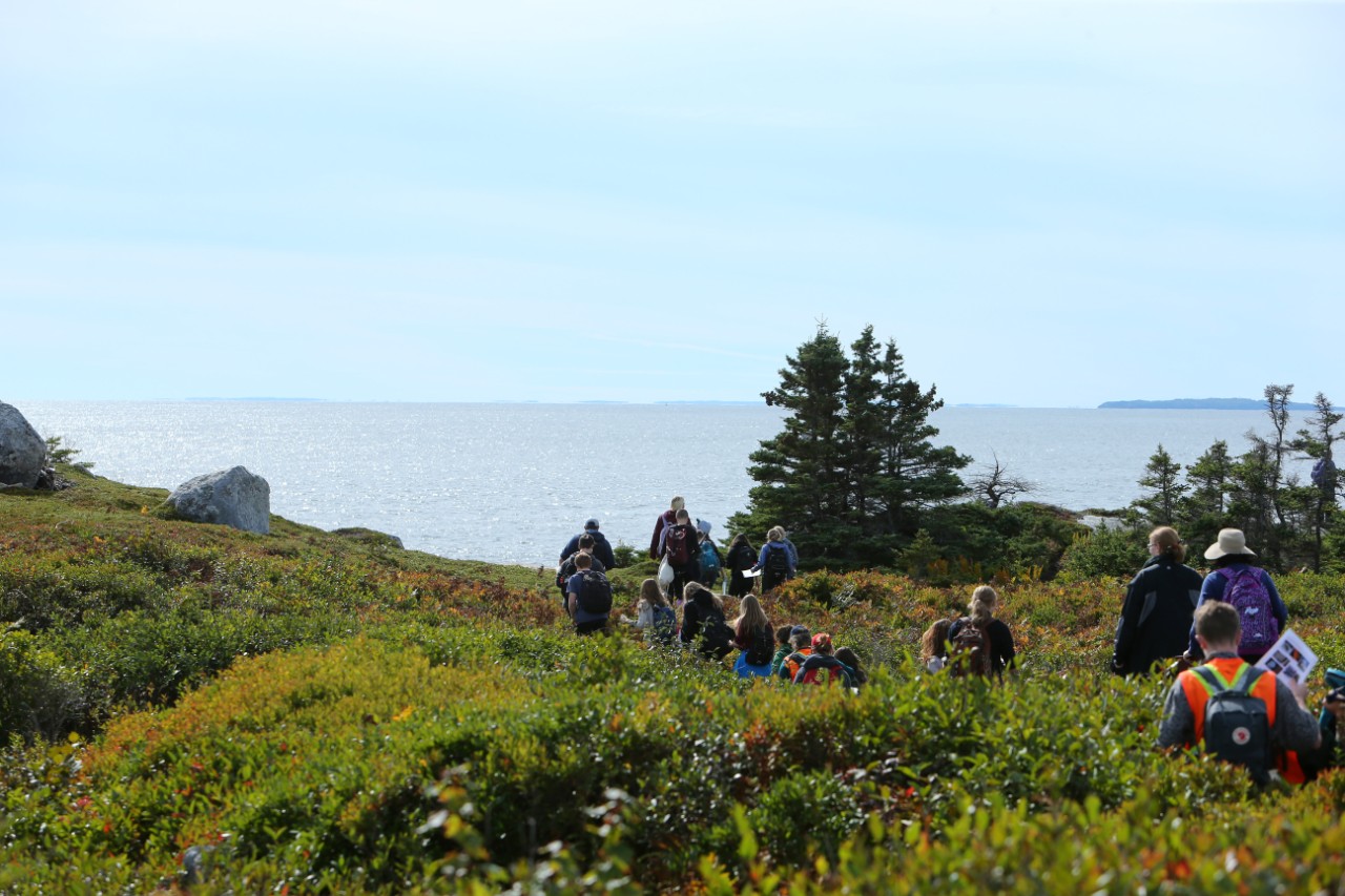 Science students walk in a group and explore the area around Peggy's Cove, Nova Scotia