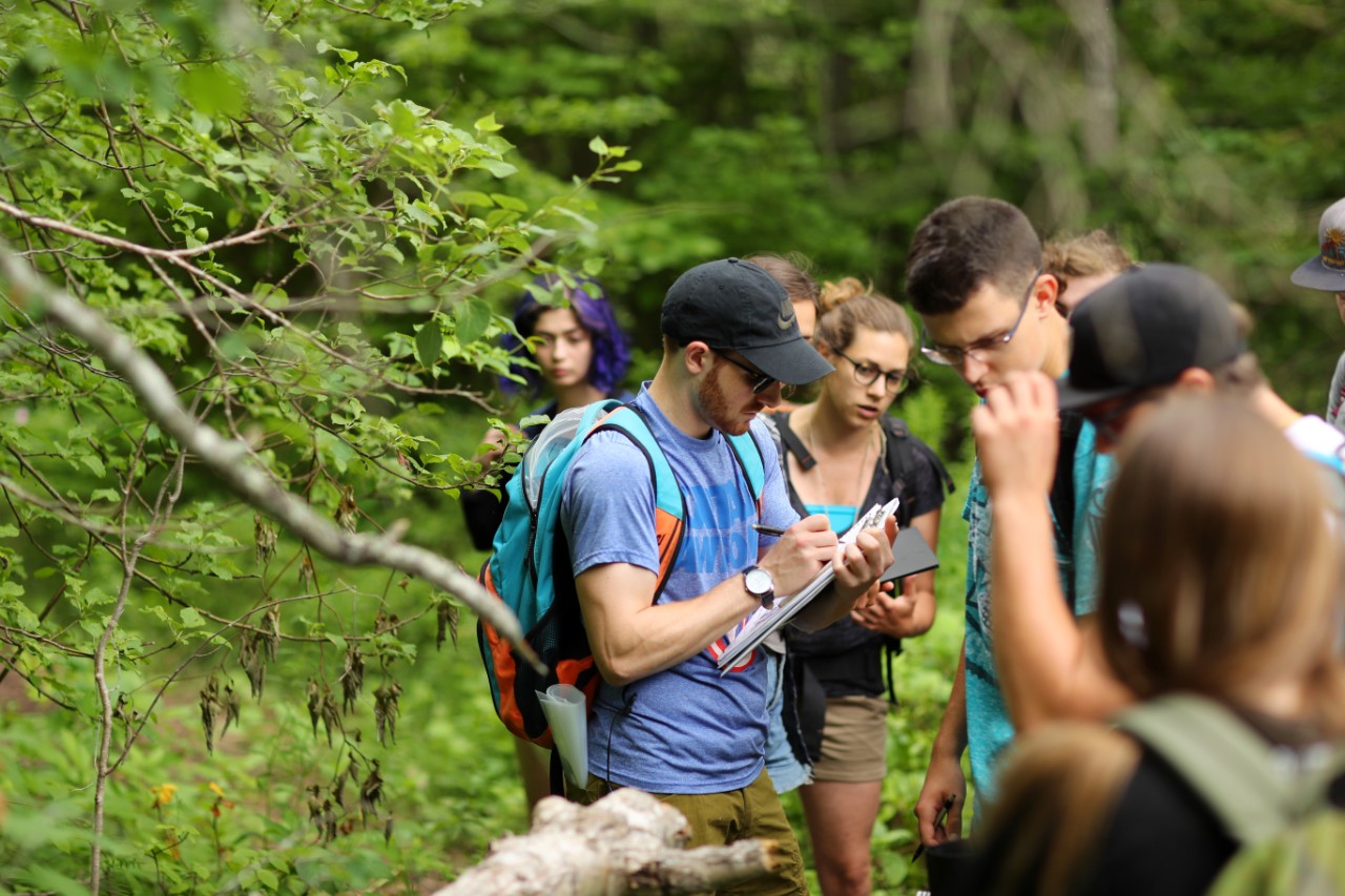 Dalhousie Science students stand on a wooded area while on a field trip