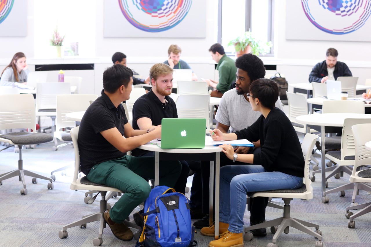 Students sit at tables talking and studying in the Department of Mathematics and Statistics