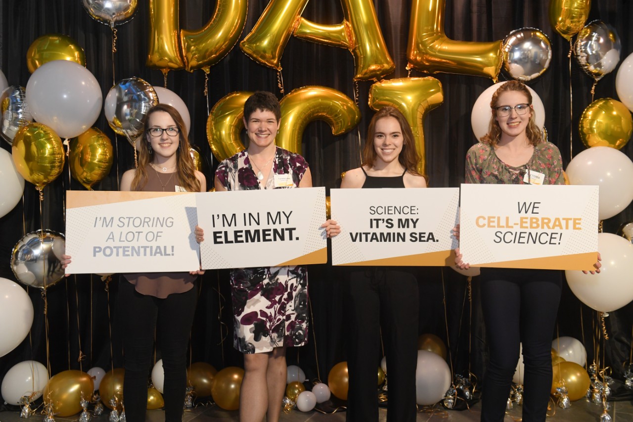 Students and faculty hold up signs while attending the Dalhousie Science Deans Reception