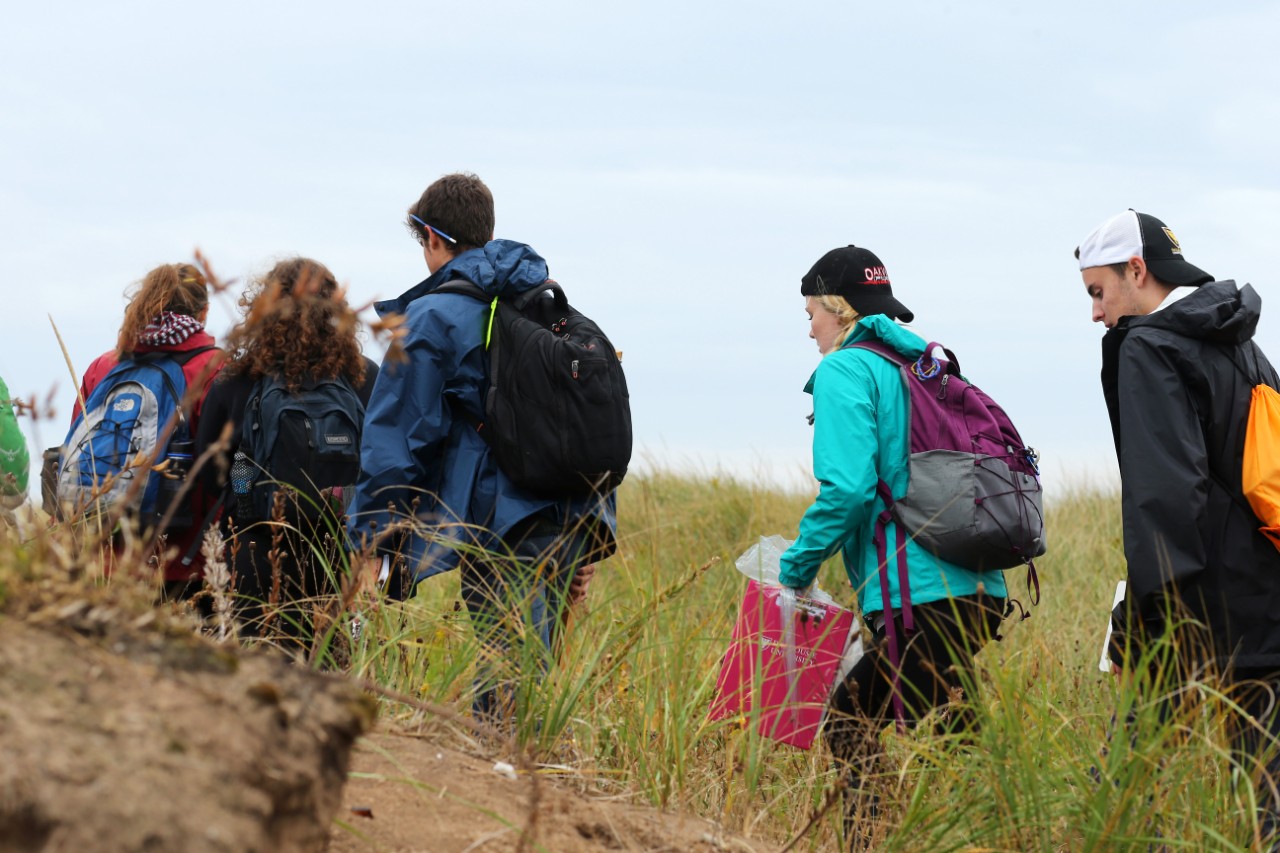 Science students explore the tall grass while they attend a field trip at Conrad's Beach, Nova Scotia