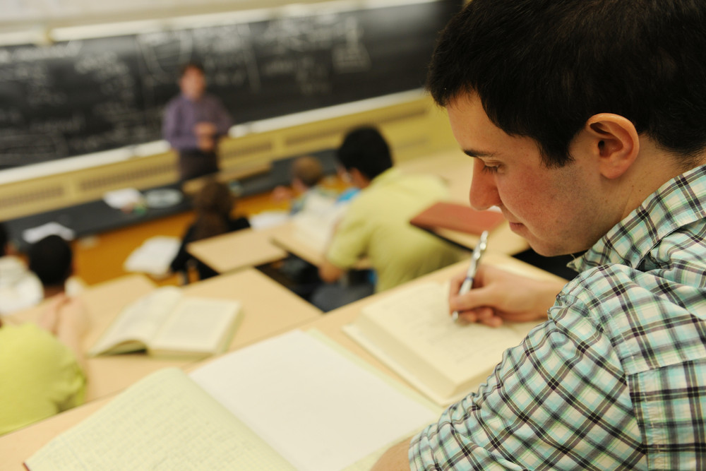 A student makes notes while attending a lecture at Dalhousie University