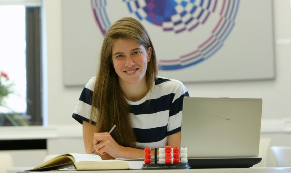 A student with a laptop works in a classroom