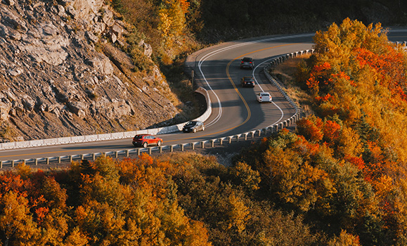 A winding highway in Cape Breton Island, Nova Scotia. Fall foliages lines the highway.