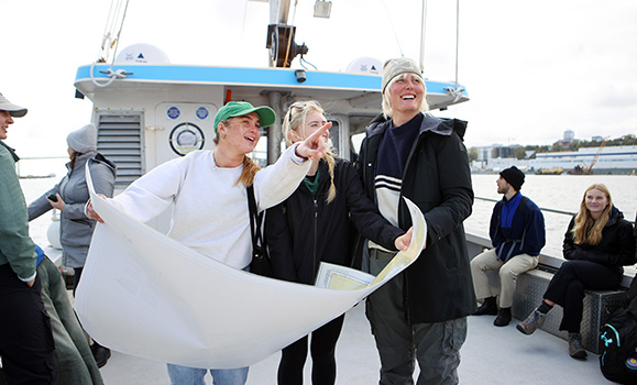 Students look at a map on board a research cruise 