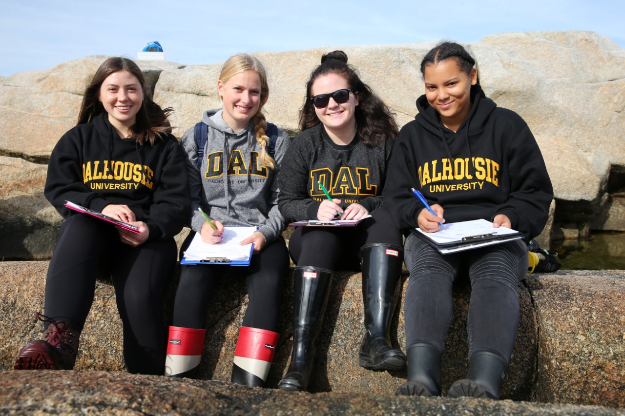 Science students sit together and make notes while they attend a field trip at Peggy's Cove, Nova Scotia