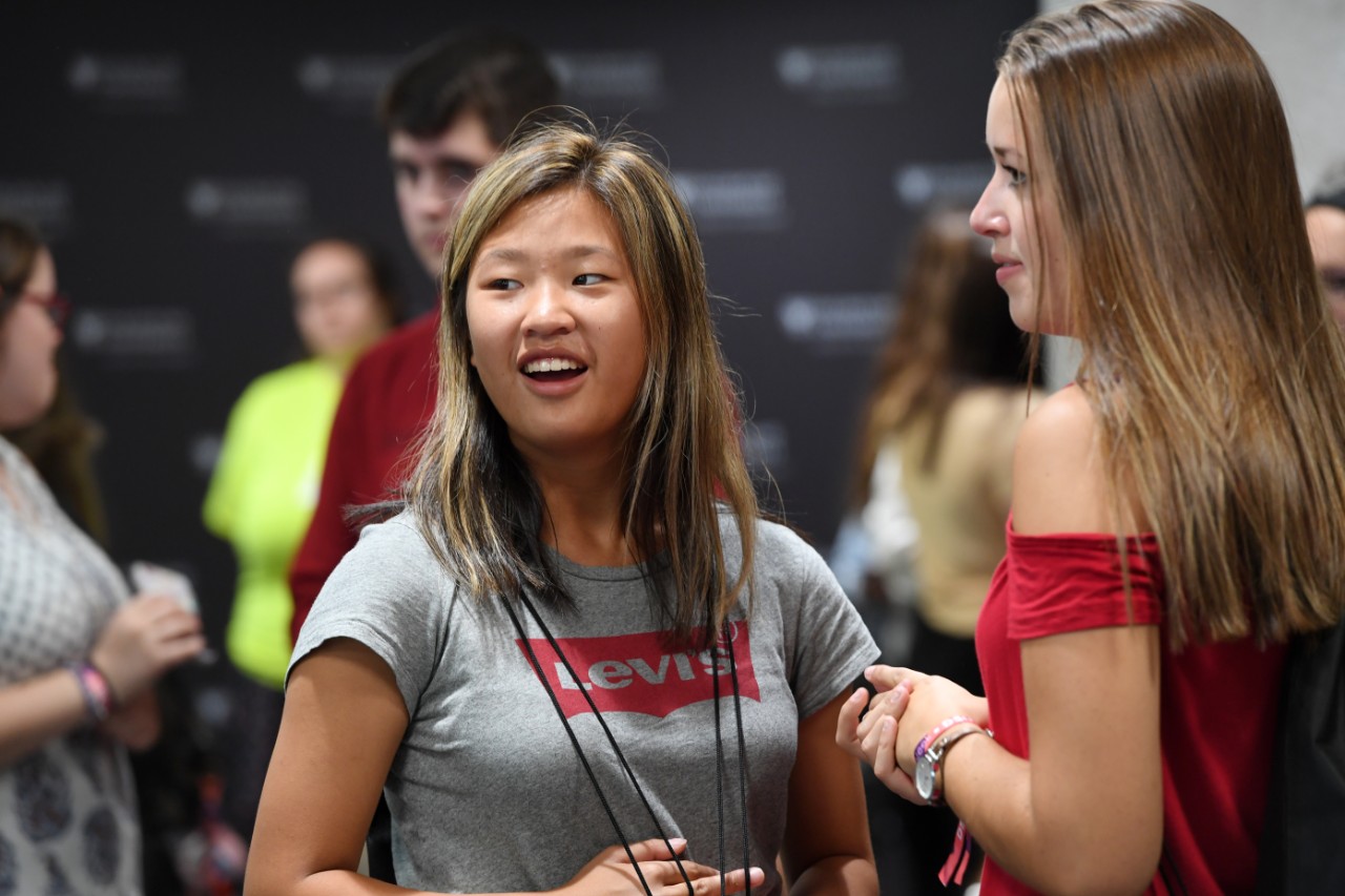 Two students chat during a welcome event