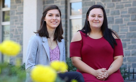 Two students walk across a university campus