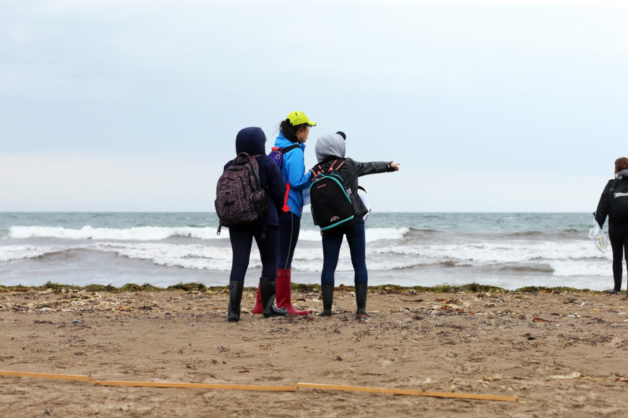 Science students looks towards the ocean while they attend a field trip at Conrad's Beach, Nova Scotia