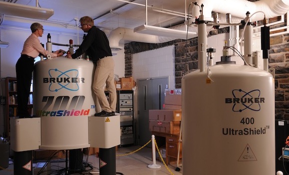 Staff work in a lab space with large tanks
