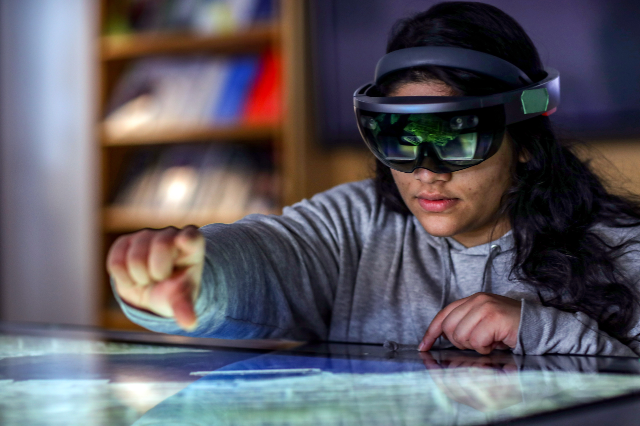A woman wearing a virtual reality headset gesturing as if to grab something