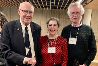 Two men and a woman standing in a group together wearing name tags