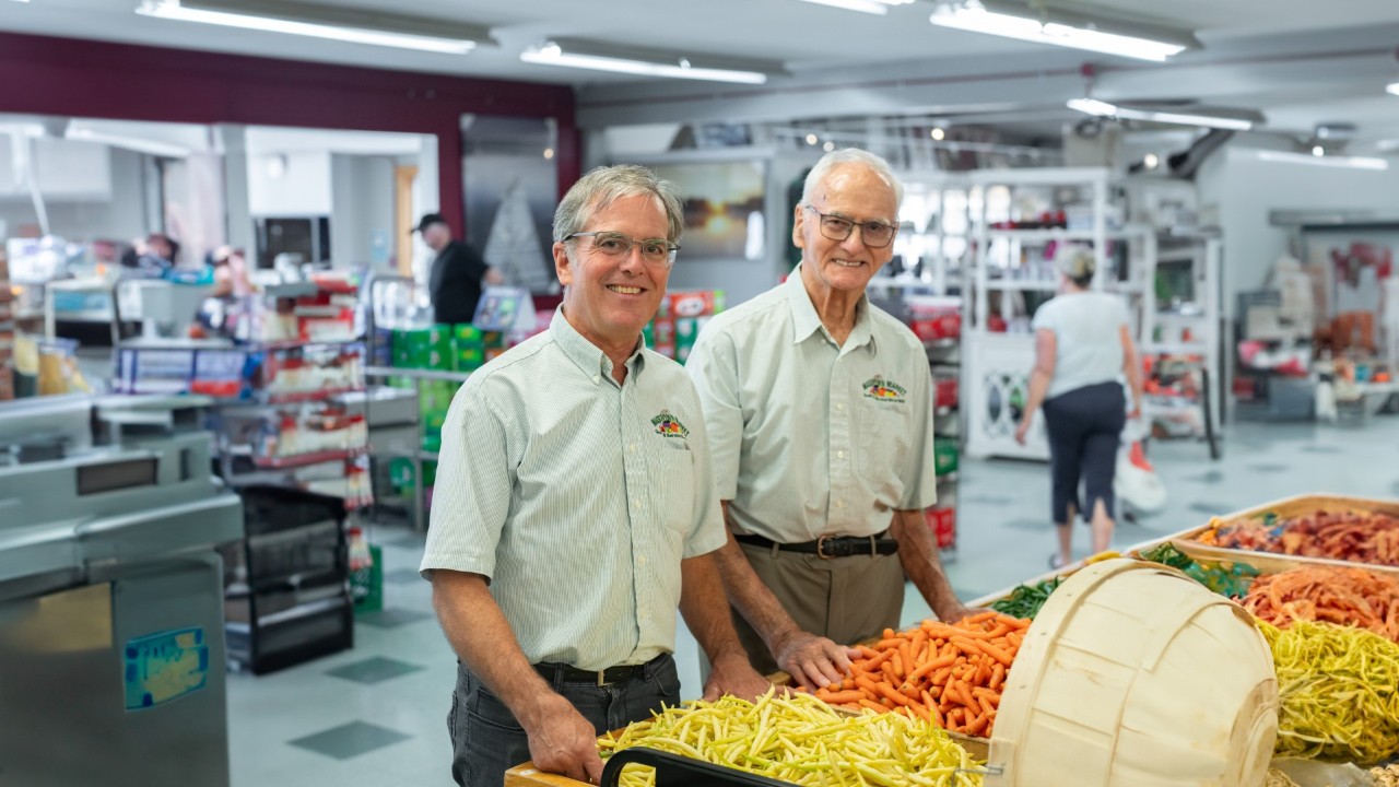 Laurie and Eric Jennings stand at a display of vegetables in the market store.