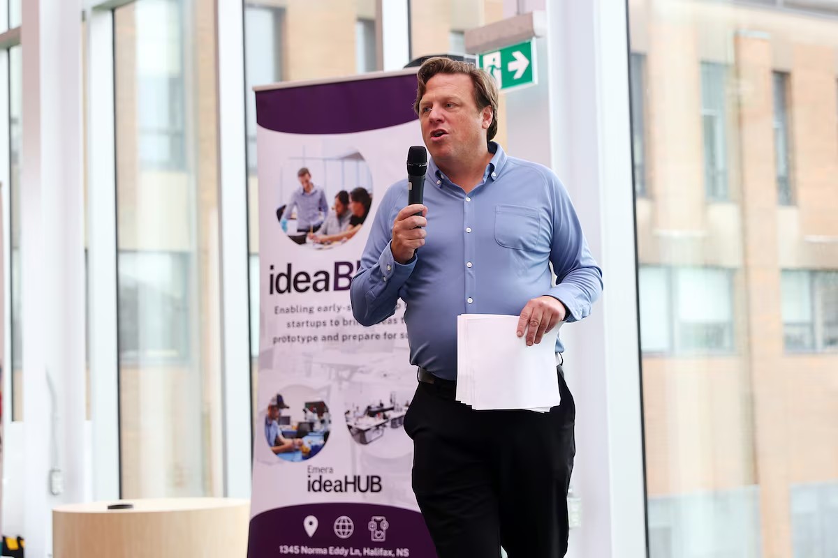 Larsen speaking into a mic at an event.