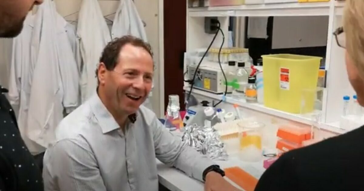 Dr. Giacomantonio sitting in a lab smiling in conversation.