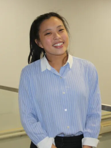 A woman with black hair wearing a blue blouse