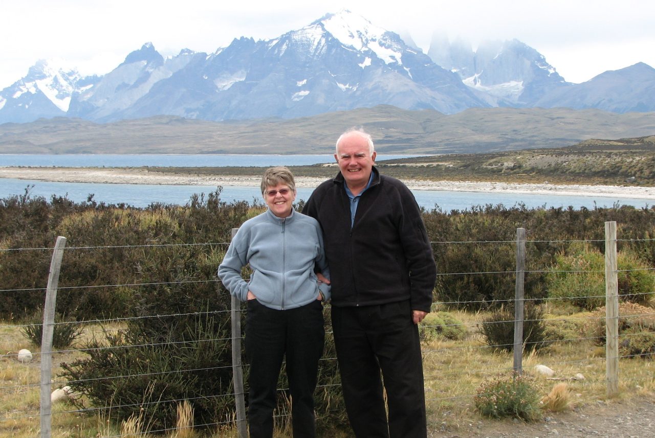 Jane and Arthur Sedgwick standing together with a snow-capped mountain range in the background.
