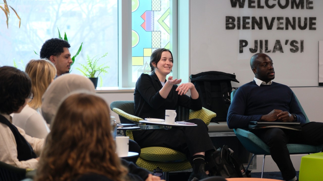 A diverse group of students in a casual learning environment dressed in business casual attire.