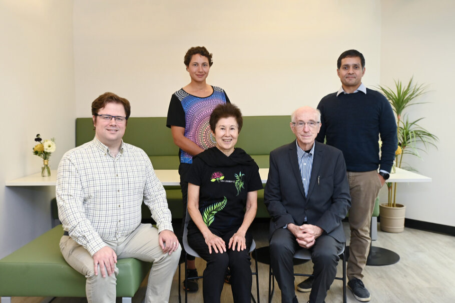 A group of people with two people standing behind three people who are seated