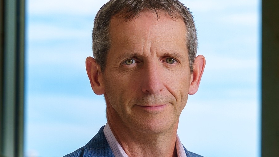 A headshot of a man with grey hair