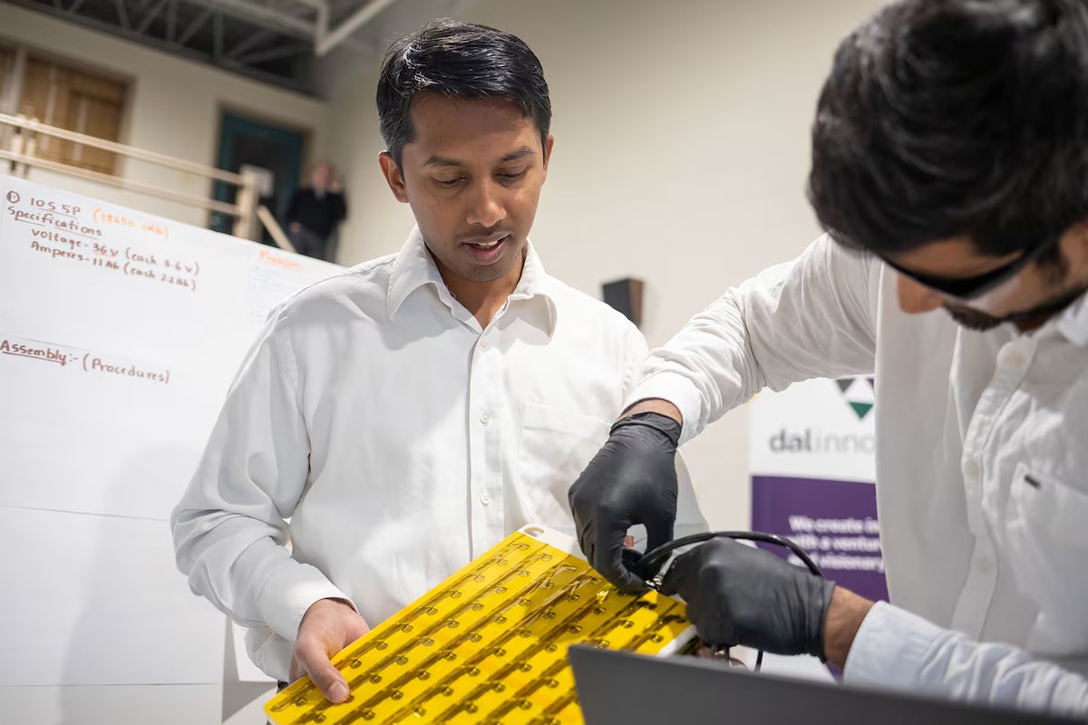 Kempaiah and a colleague demonstrate one of their company's battery products at an event.