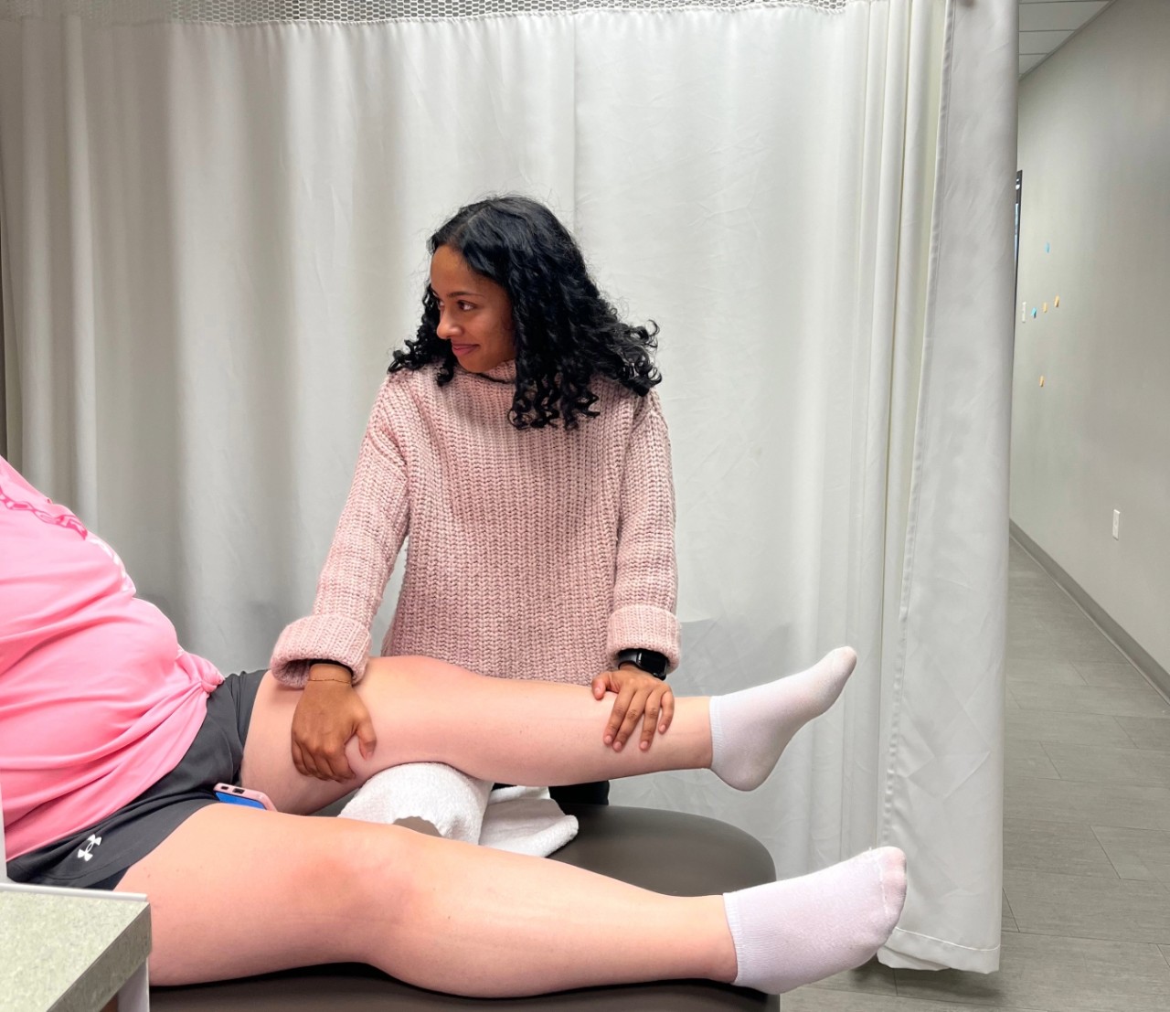 Cherian works with a patient in a clinic.