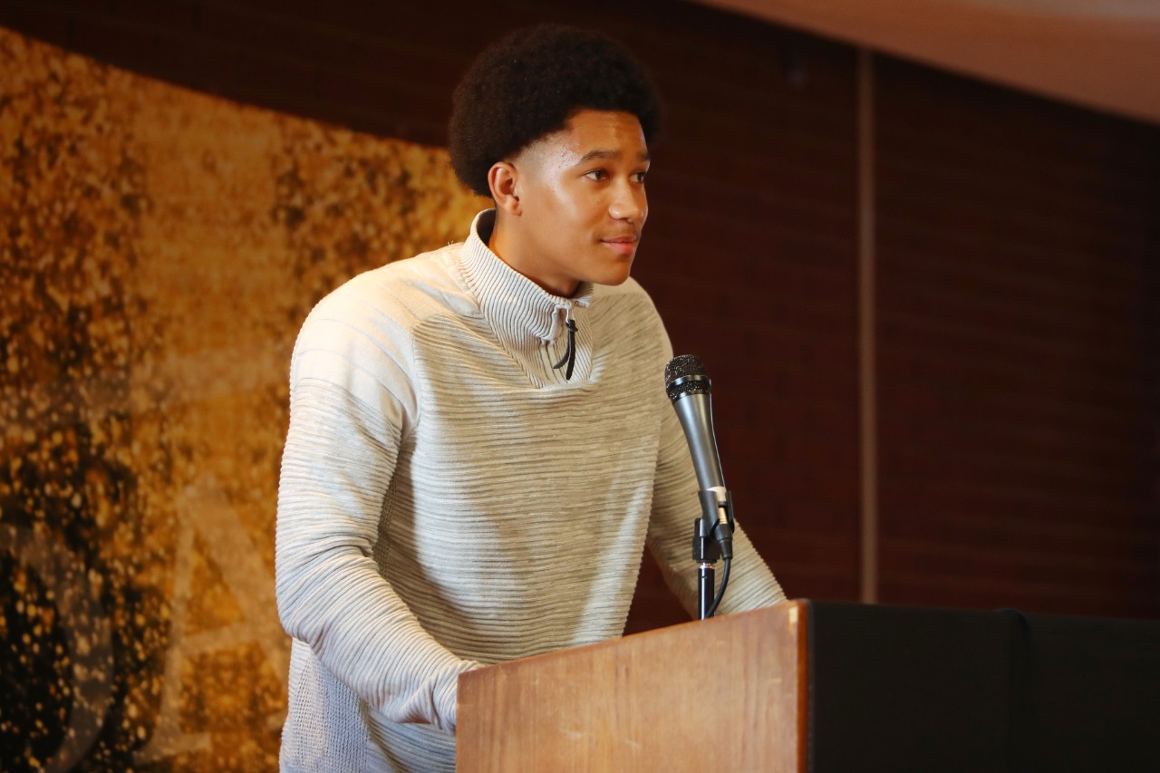 A young man stands at a podium