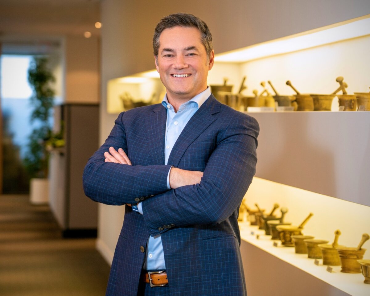 A man wearing a blue suit posing with his arms crossed