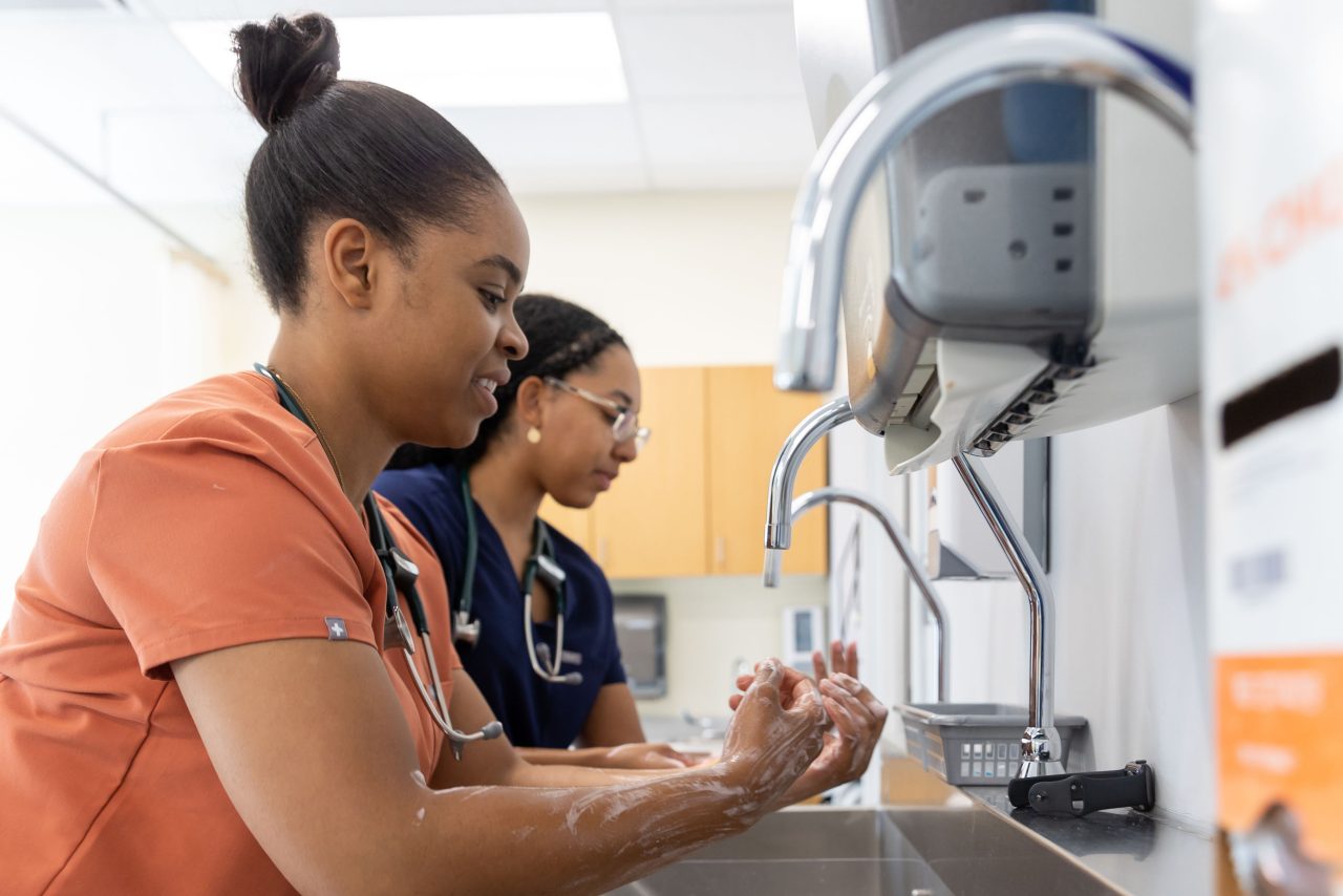 two medical staff wash their hands