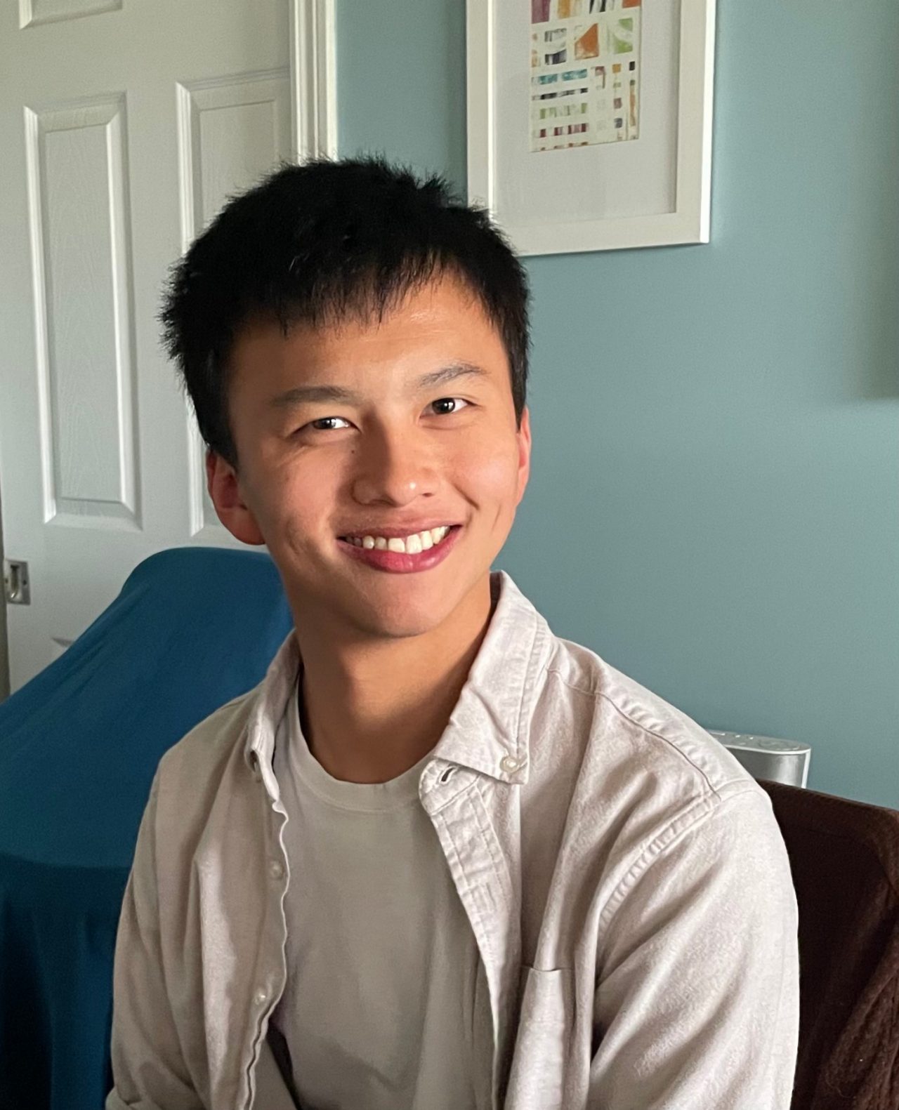 Coby Steer seated indoors, smiling.