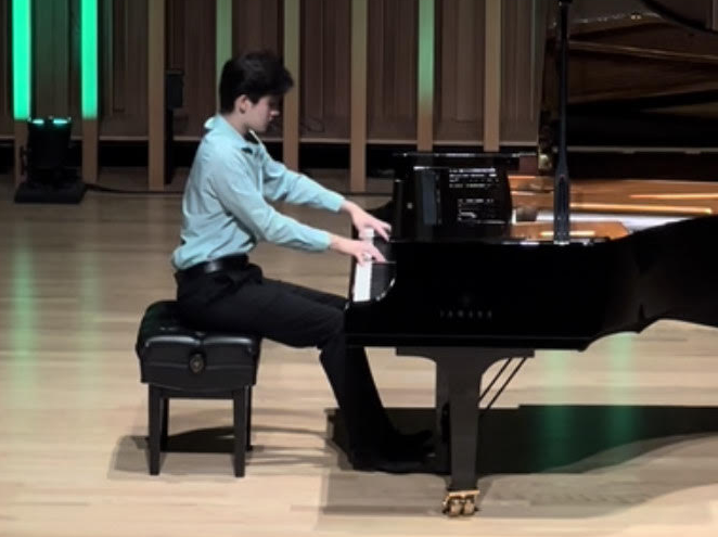 Spiliopoulos playing the piano on stage in the Strug Concert Hall.