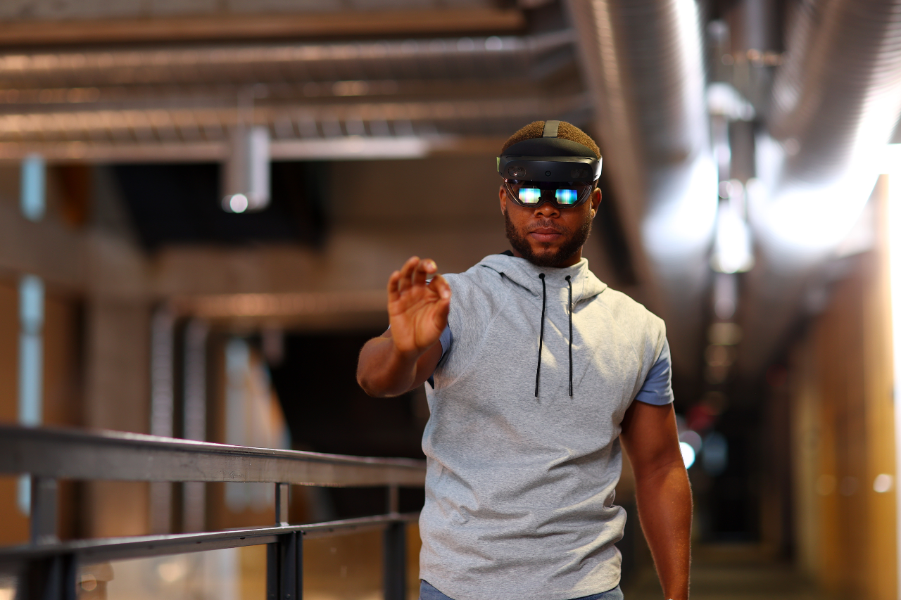 A man wearing a virtual reality headset reaches out to grab something