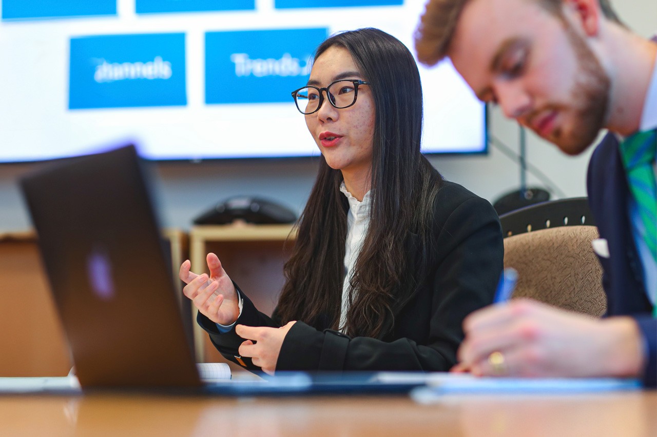 professional master's students giving a presentation and taking notes