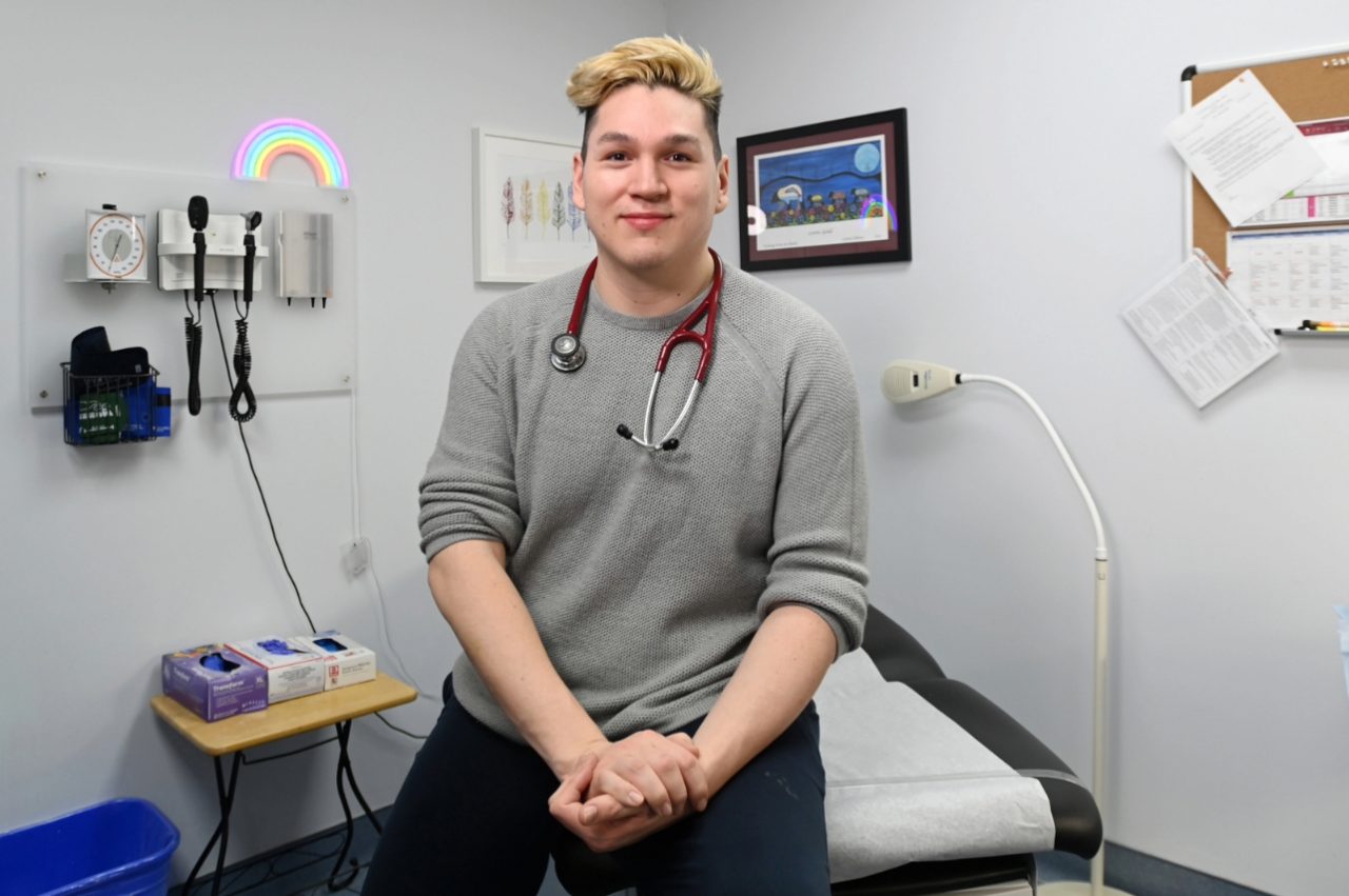 Sylliboy is sitting on the edge of an exam table in a medical clinic.