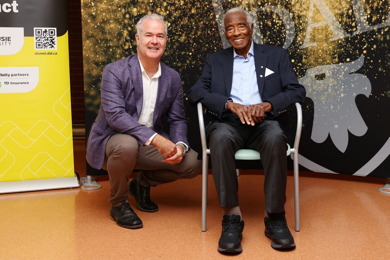 Dawe and Oliver, seated in chair, together at an event. 